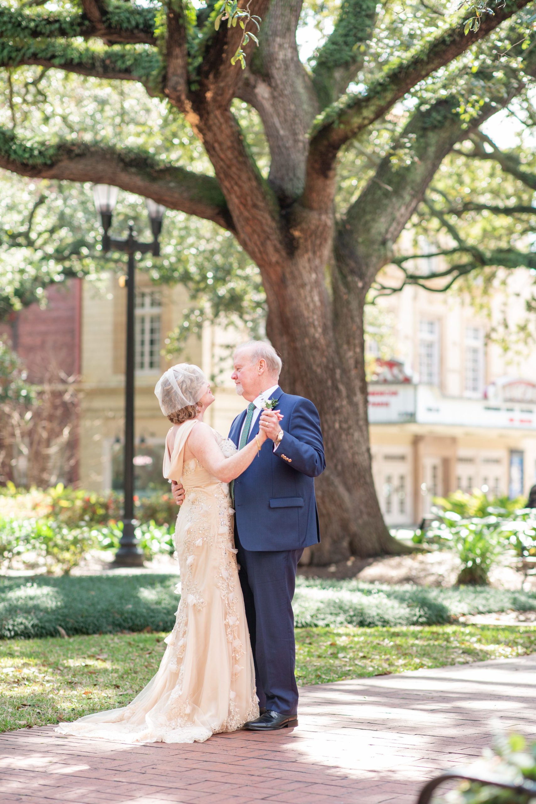 wedding couple dancing in square in front of old pink house in savannah