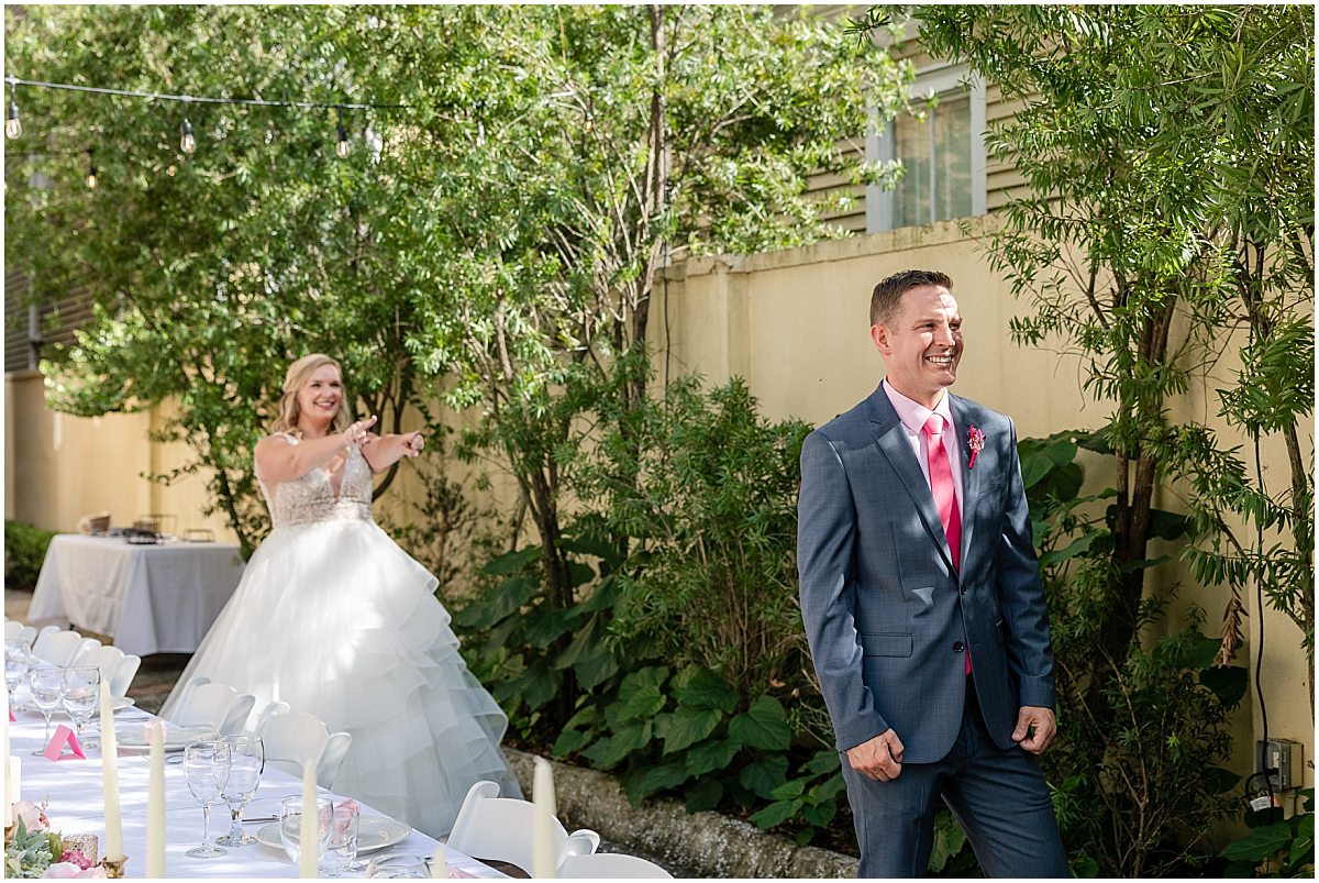 bride behind groom waiting for him to turn around and see her for first time