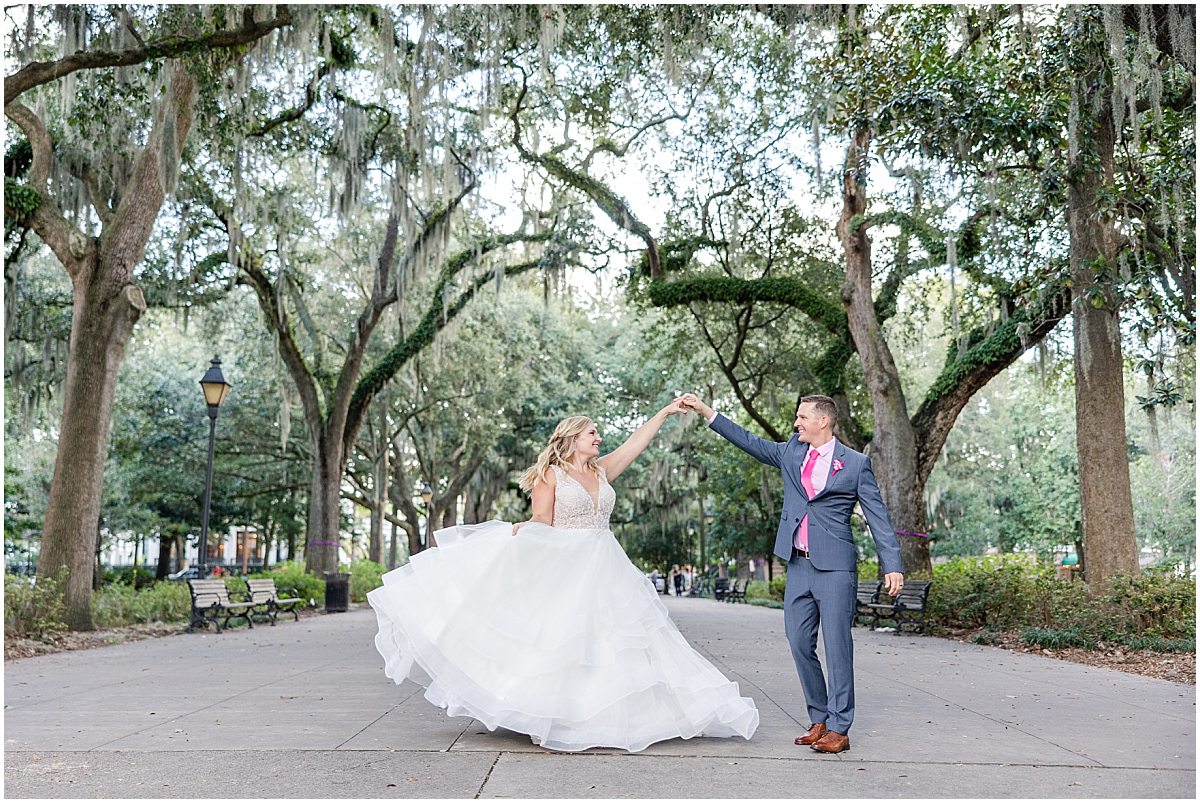 groom twirling bride in forsyth park by savannah wedding photographer amber elizabeth weddings