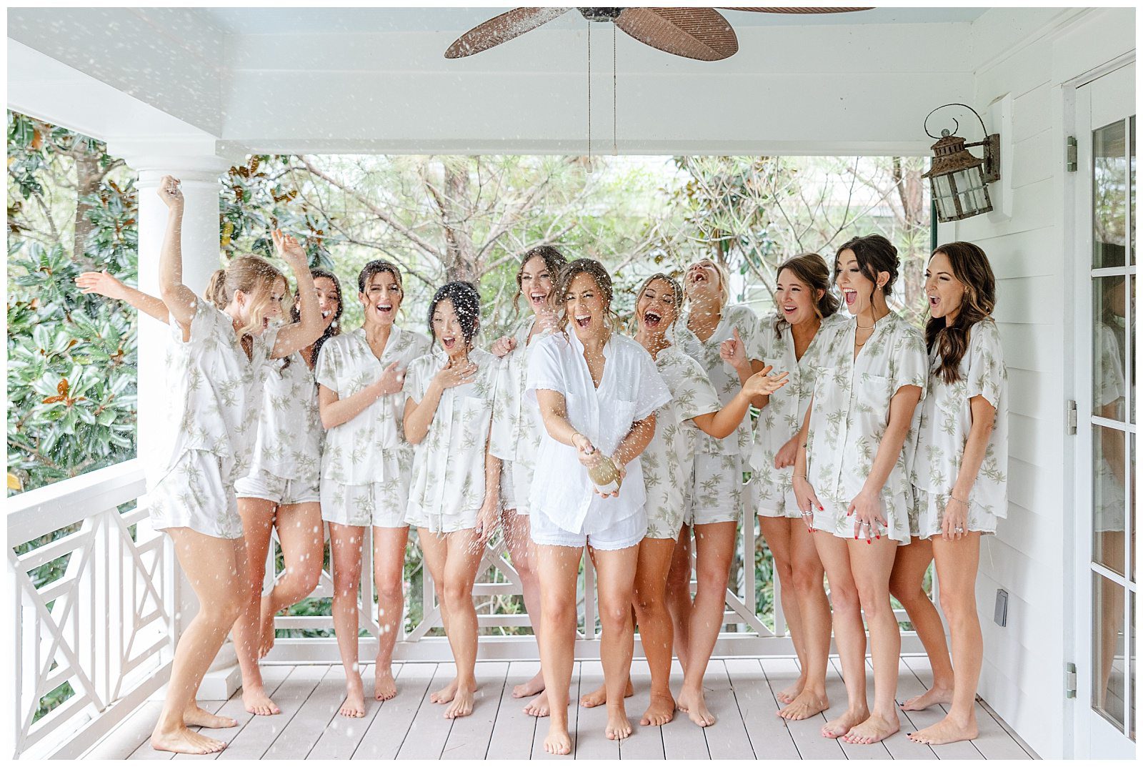 bridesmaids in matching pajamas popping champagne